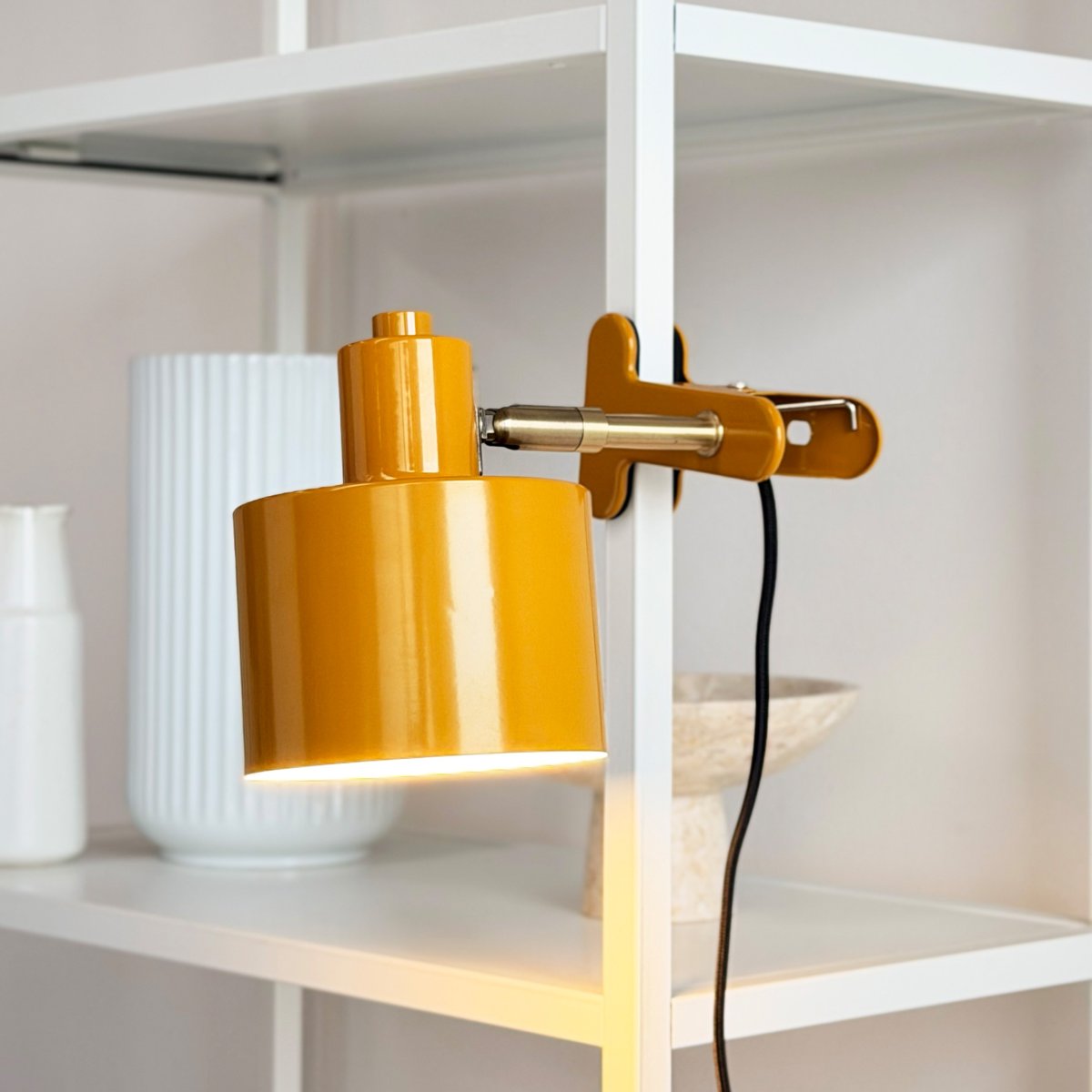 Ocean Gul klemmelampe Fra Dyberg Larsen - Den kombinerer funksjonalitet med et moderne og enkelt design som skaper et rolig og elegant uttrykk.