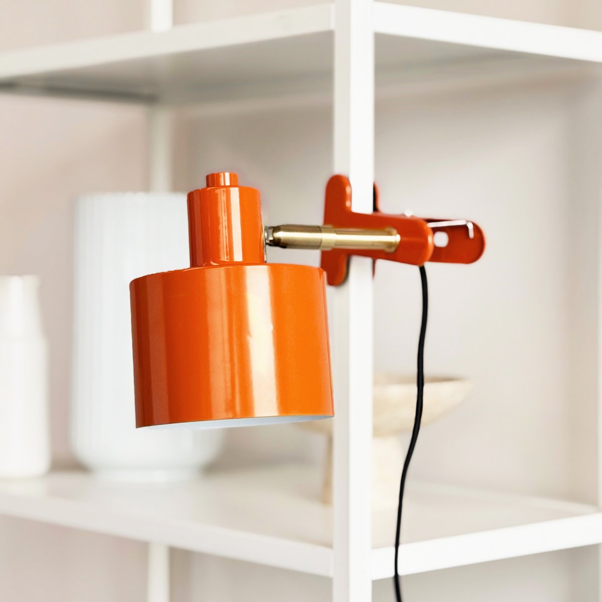 Ocean Oransje klemmelampe Fra Dyberg Larsen - Den kombinerer funksjonalitet med et moderne og enkelt design som skaper et rolig og elegant uttrykk.