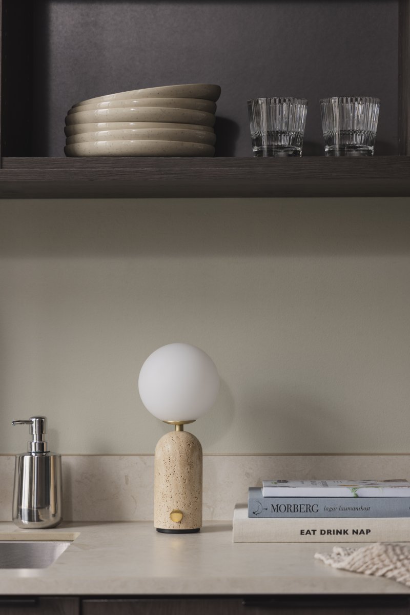 Torrano 28cm Beige travertin bærbar Fra Globen Lighting - Den massive basen i naturstein gir lampen vekt og karakter, mens den runde hvite opalglasskjermen sprer et behagelig lys.
