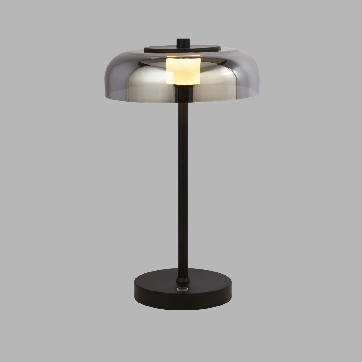 Frisbee 40cm Svart bordlampe Fra Searchlight - Med sin unike, futuristiske design og metalliske nyanse sprer den et behagelig og mykt lys som skaper en avslappet atmosfære.