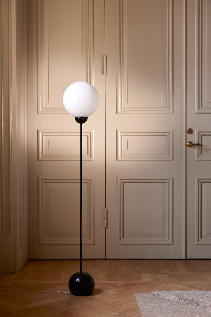 Ripley Svart gulvlampe Fra Globen Lighting - Lampen er laget av metall og har en glasskuppel i opalhvitt glass som sprer et herlig lys.
