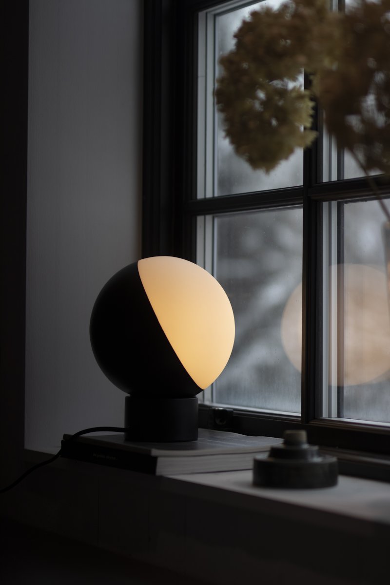 Contur 24cm Svart bordlampe Fra Globen Lighting - Lampen er laget av matt hvitt glass, hvorav halvparten er lasert i matt svart, lyset siver fint gjennom det hvite glasset.