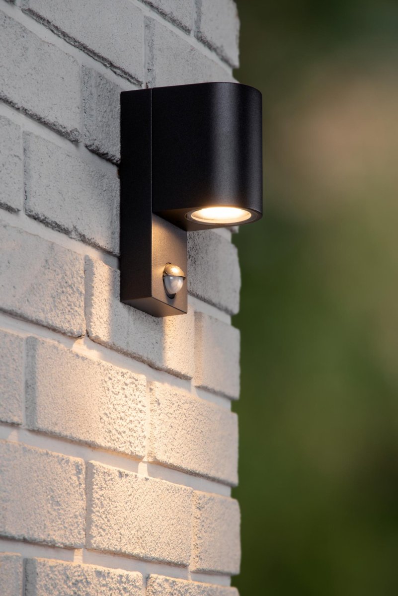 Zaro Ir Svart utendørslampe Fra Lucide - Men Zaro IR tilbyr så mye mer: denne kompakte, moderne vegglampen, laget av høykvalitets aluminium, gir nedoverrettet lys som effektivt lyser opp fasaden, oppkjørselen eller oppkjørselen din – så at du kan nyte utemiljøet dittö äenda mer.