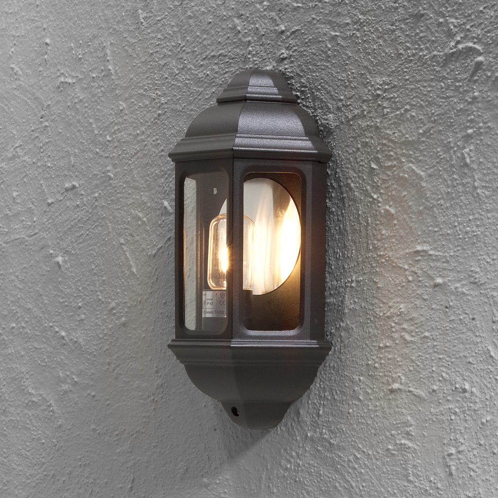 Cagliari Svart utendørslampe Fra Konstsmide - Med sitt myke lys skaper den en innbydende atmosfære som er perfekt for innganger og uteplasser.