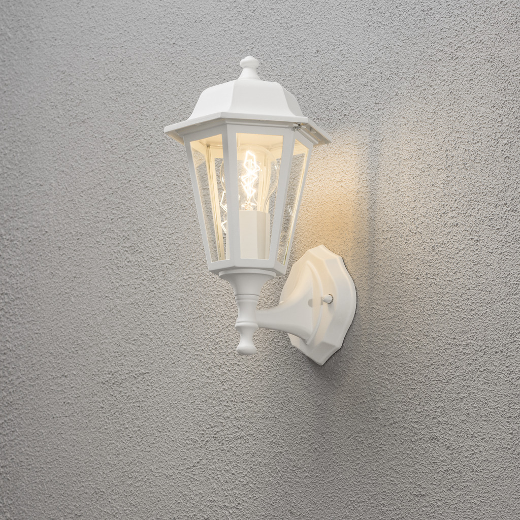 Vägglykta Hvit utendørslampe Fra Konstsmide - Med sitt lanterneformede design og klare glassfelt sprer lampen et varmt og innbydende lys som er perfekt for innganger, uteplasser og gangveier.