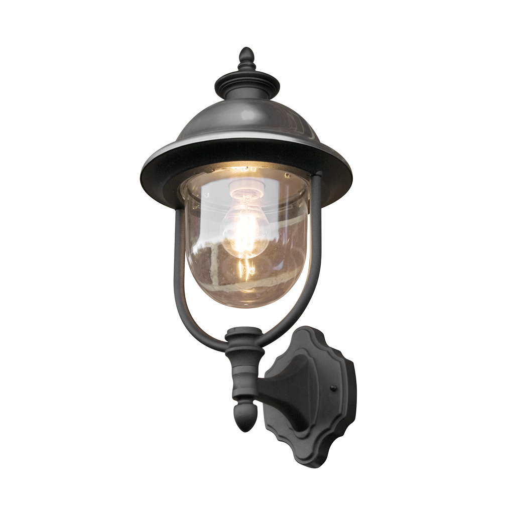 Parma Svart utendørslampe Fra Konstsmide - Med sin robuste svarte finish og klare glasskuppel sprer den en varm og innbydende glød, og skaper en innbydende atmosfære ved inngangen eller uteplassen.
