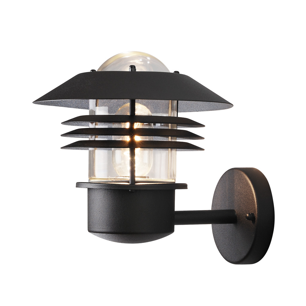 Modena Svart utendørslampe Fra Konstsmide - Med sitt beskyttende tak og stilige design gir den et behagelig og rettet lys, ideelt for å skape en trygg og innbydende atmosfære utendørs.