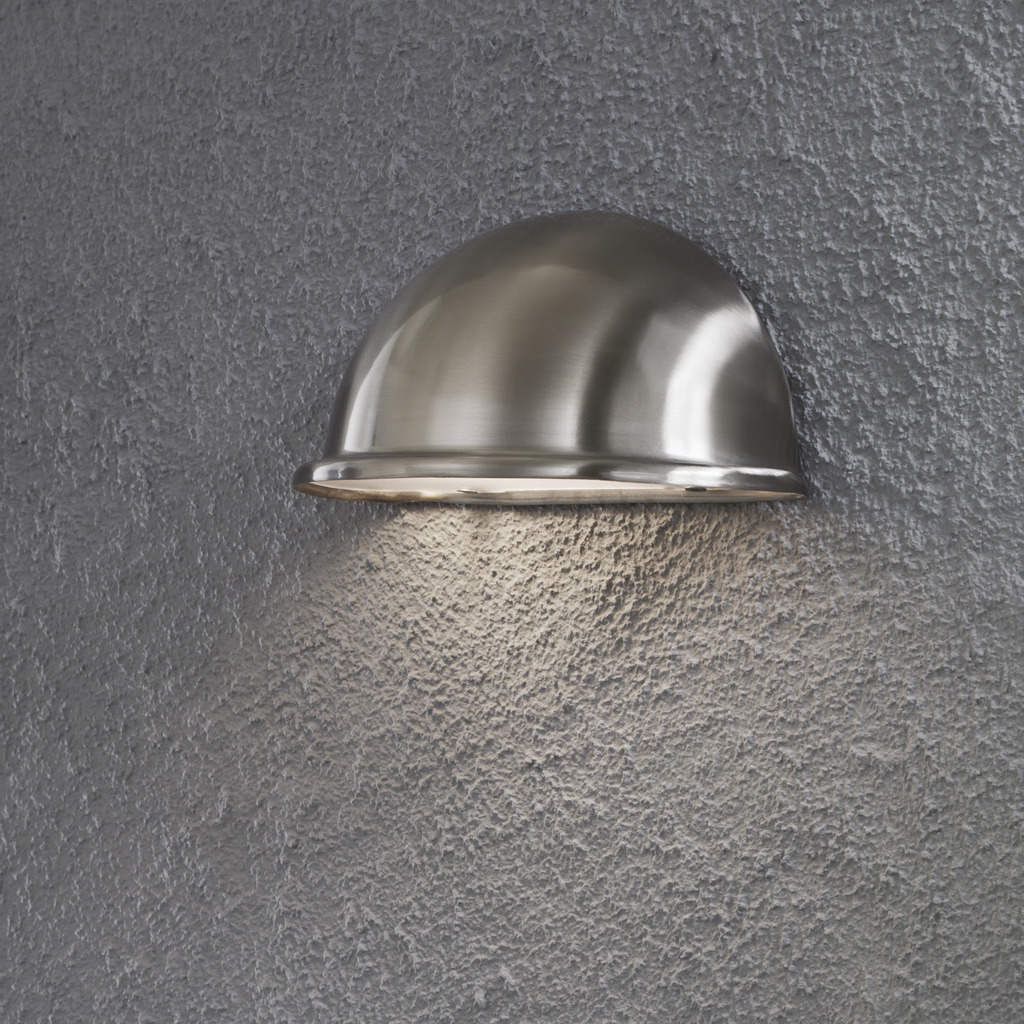 Torino Sølv utendørslampe Fra Konstsmide - Designet i rustfritt stål og den minimalistiske halvmåneformen gir et subtilt og behagelig lys som er perfekt for uteplasser, ganger og innganger.