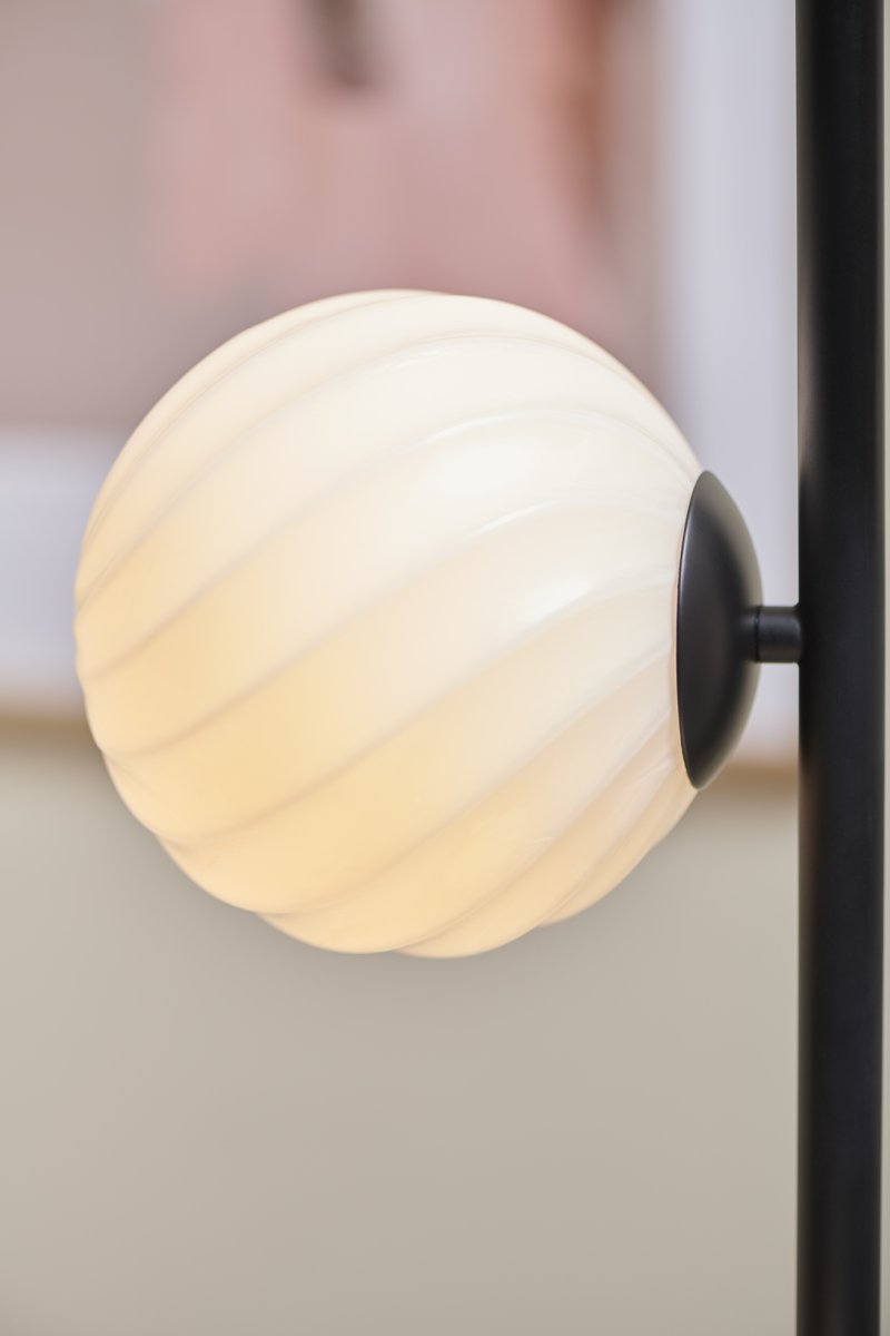 Twist Svart gulvlampe Fra Halo Design - Lampens mattsvarte ramme og myke lys skaper en perfekt balanse mellom modernitet og varme.