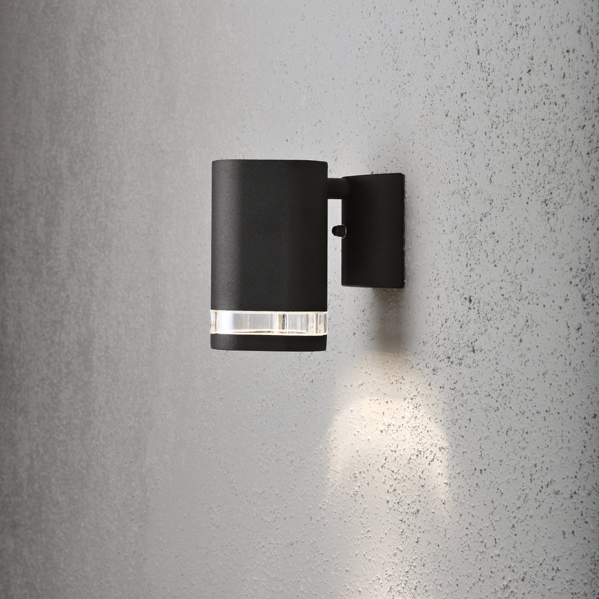 Modena Svart utendørslampe Fra Konstsmide - Modena er en stilig fasadelampe i sortlakkert aluminium med en elegant detalj i transparent akrylglass som gir lampen et moderne uttrykk.