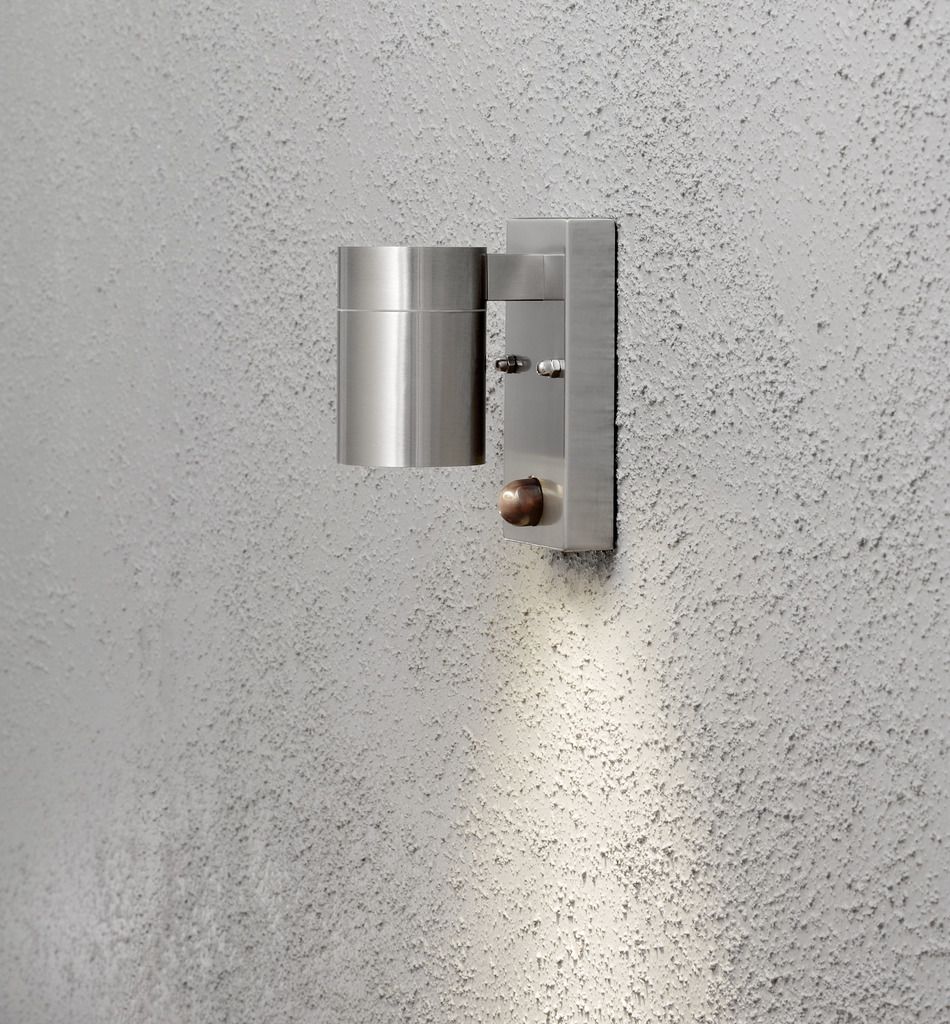 Modena Sølv utendørslampe Fra Konstsmide - Lampens stilige og moderne design smelter inn i alle fasader og slår seg på automatisk når den registrerer bevegelse, noe som gir ekstra trygghet i innganger og ganger.