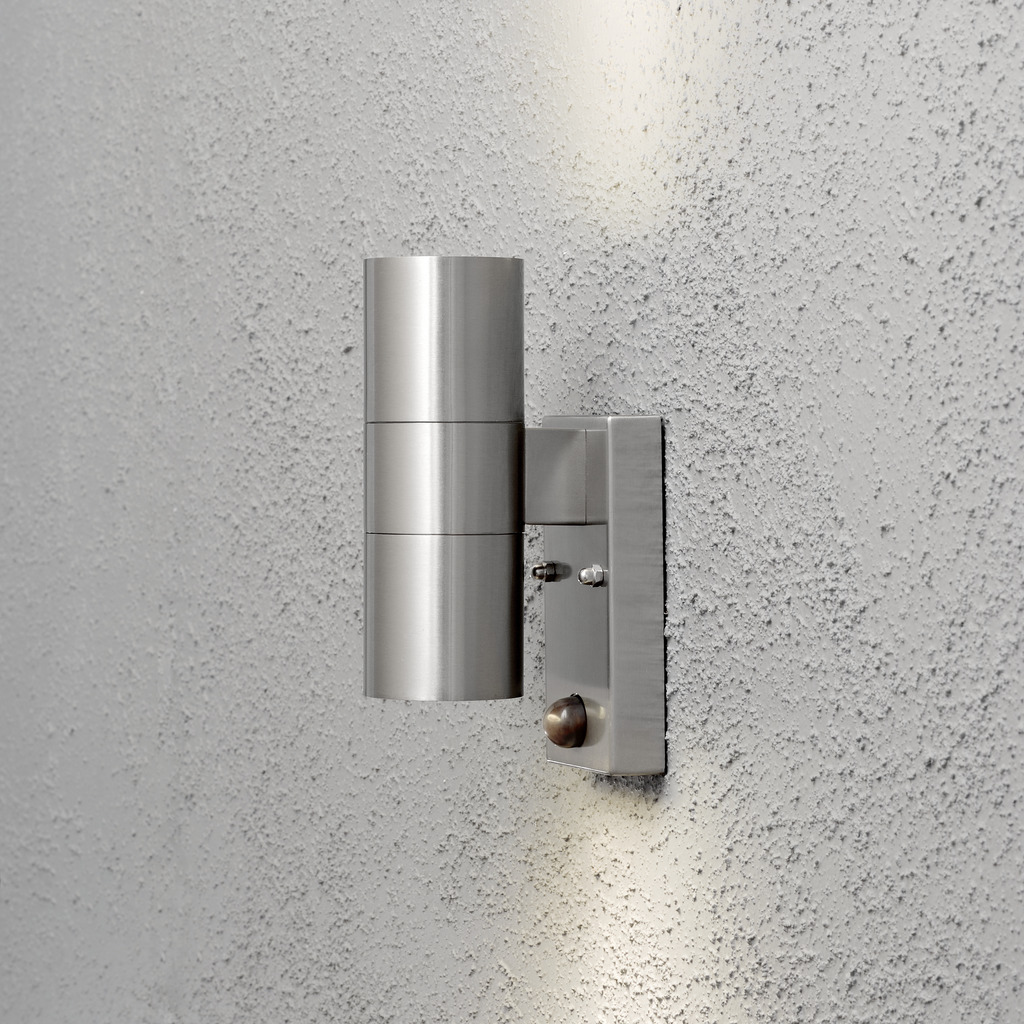 Modena Sølv utendørslampe Fra Konstsmide - Lampens stilige og moderne design smelter inn i alle fasader og slår seg på automatisk når den registrerer bevegelse, noe som gir ekstra trygghet i innganger og ganger.