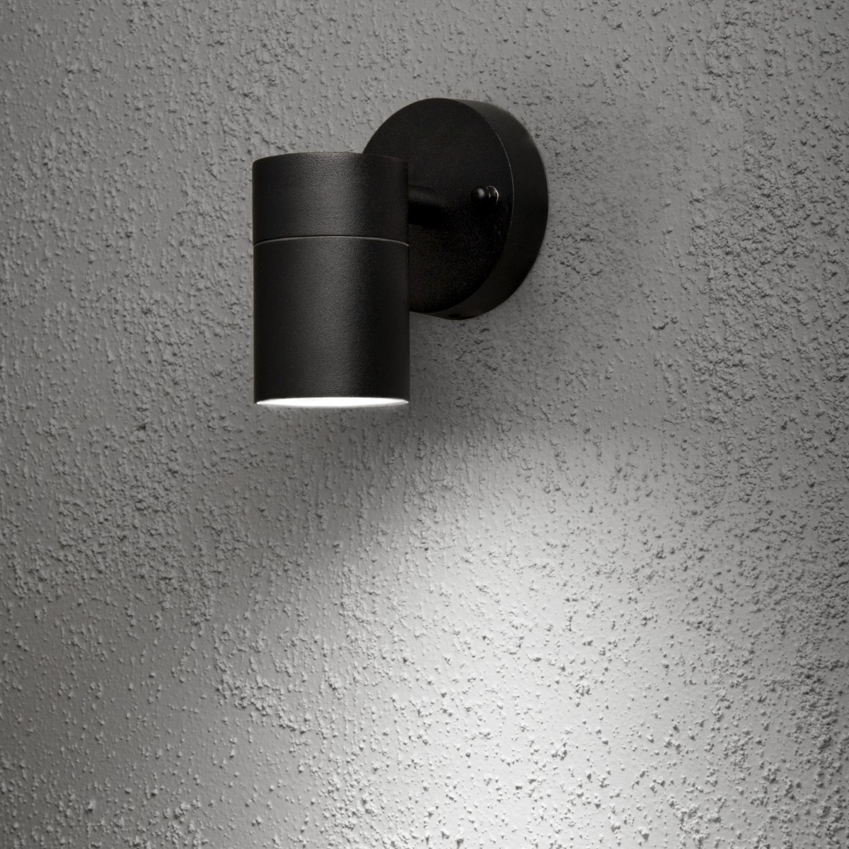 Modena Svart utendørslampe Fra Konstsmide - Lyset er rettet nedover og skaper et mykt og effektivt lysbilde som fremhever fasaden og gir behagelig utend&oslash;rsbelysning.