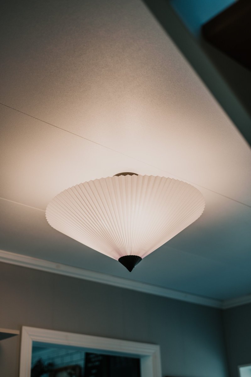 Matisse Ø60 Hvit plafond Fra Globen Lighting - Lampen har en plissert hvit tekstilskjerm og er dekorert med en matchende plissert topp i matt sortlakkert metall.