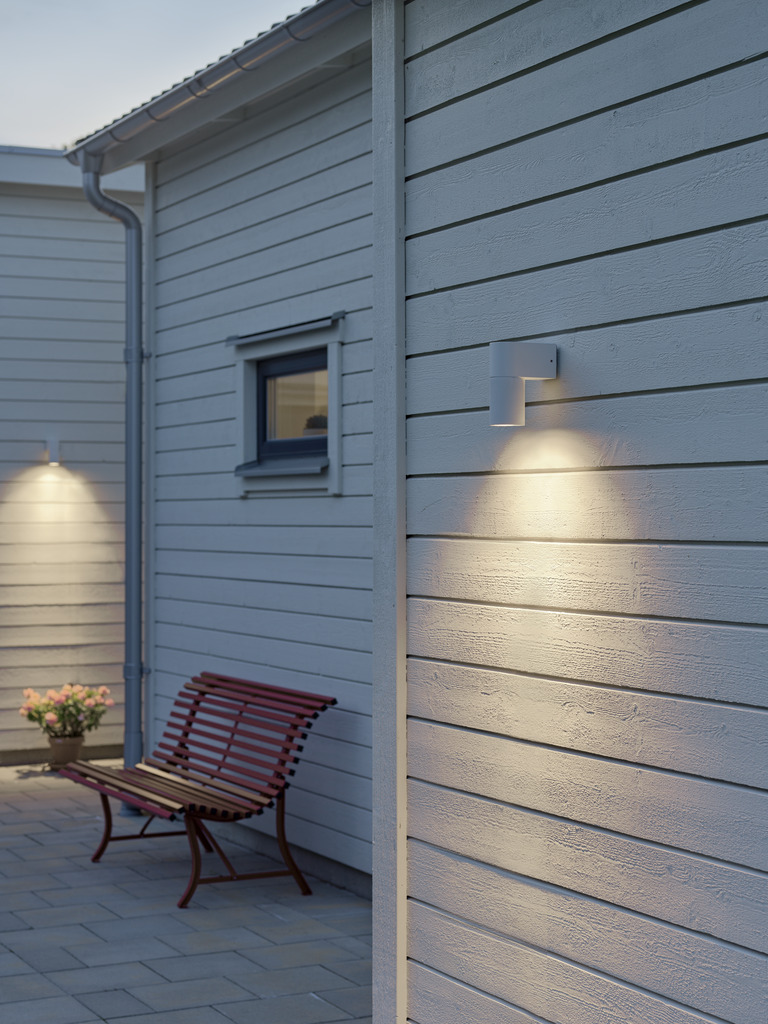 Temi Hvit utendørslampe Fra Konstsmide - Med sin runde design og direkte lys er den ideell for å skape en sofistikert atmosfære i entréer og ganger.