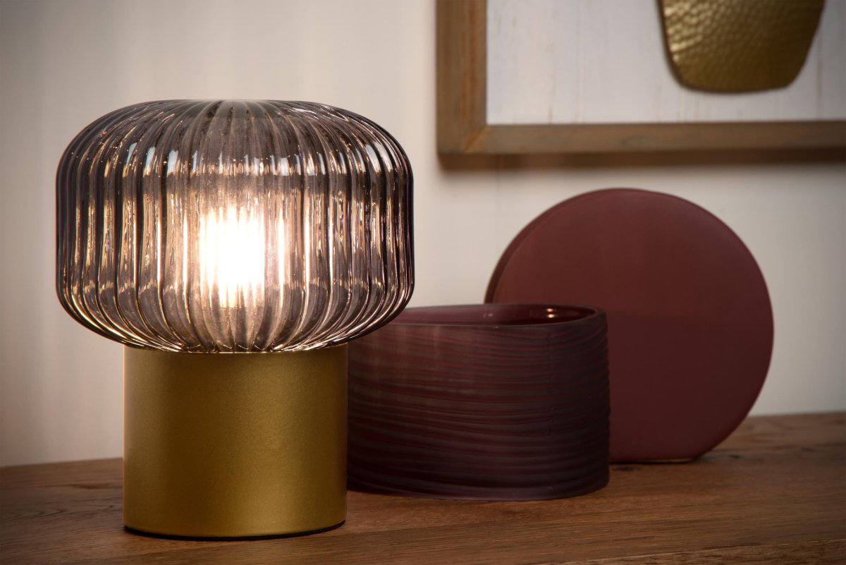 Jany 18cm Matt gull/messing bordlampe Fra Lucide - Den metalliske basen er en helt glatt sylinder, mens glasset rundt lyskilden er alt annet enn flatt.