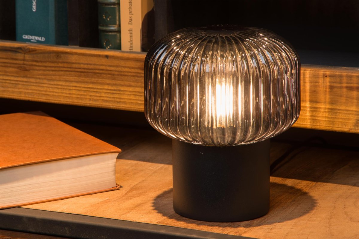 Jany 18cm Svart bordlampe Fra Lucide - Den metalliske basen er en helt glatt sylinder, mens glasset rundt lyskilden er alt annet enn flatt.