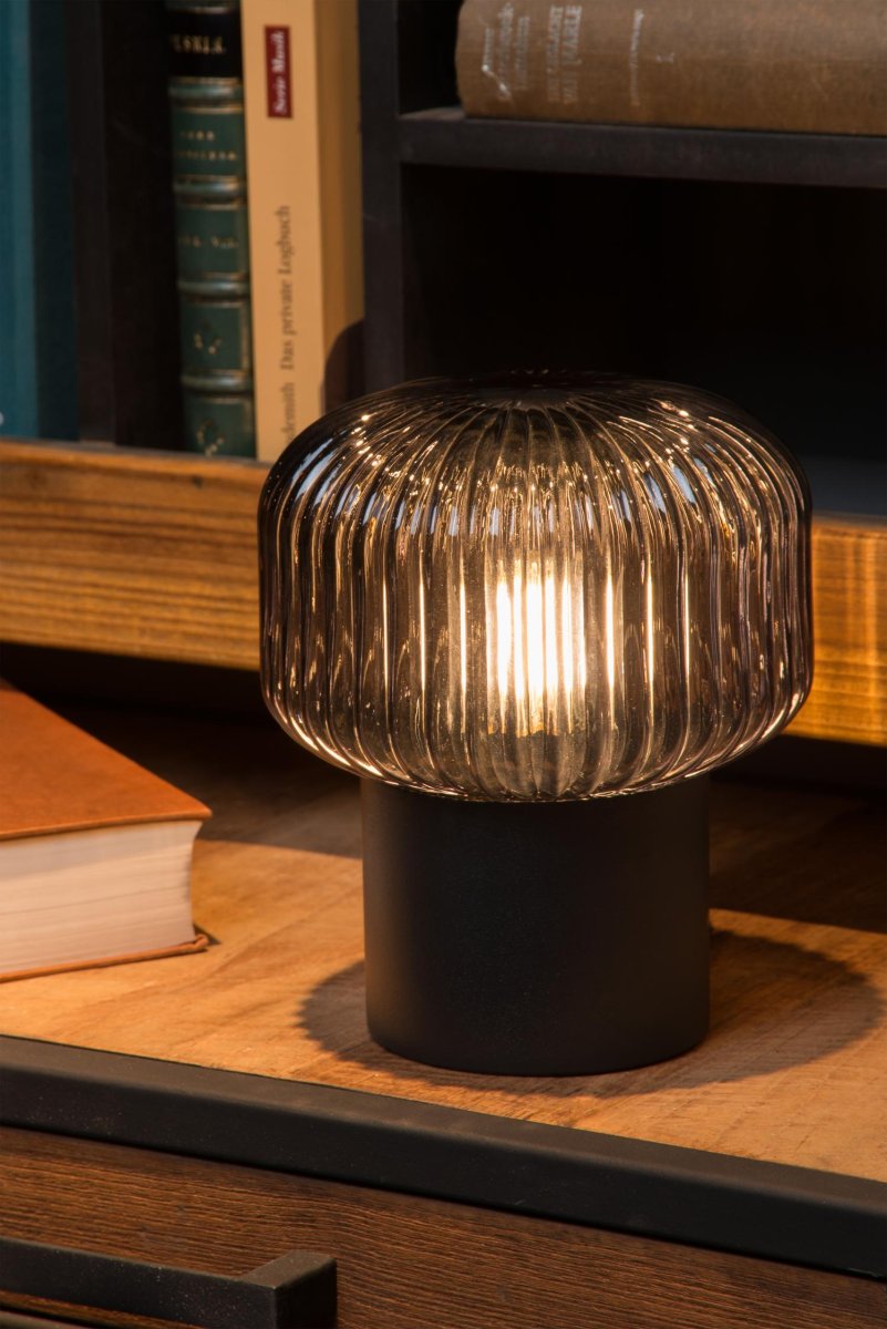 Jany 18cm Svart bordlampe Fra Lucide - Den metalliske basen er en helt glatt sylinder, mens glasset rundt lyskilden er alt annet enn flatt.