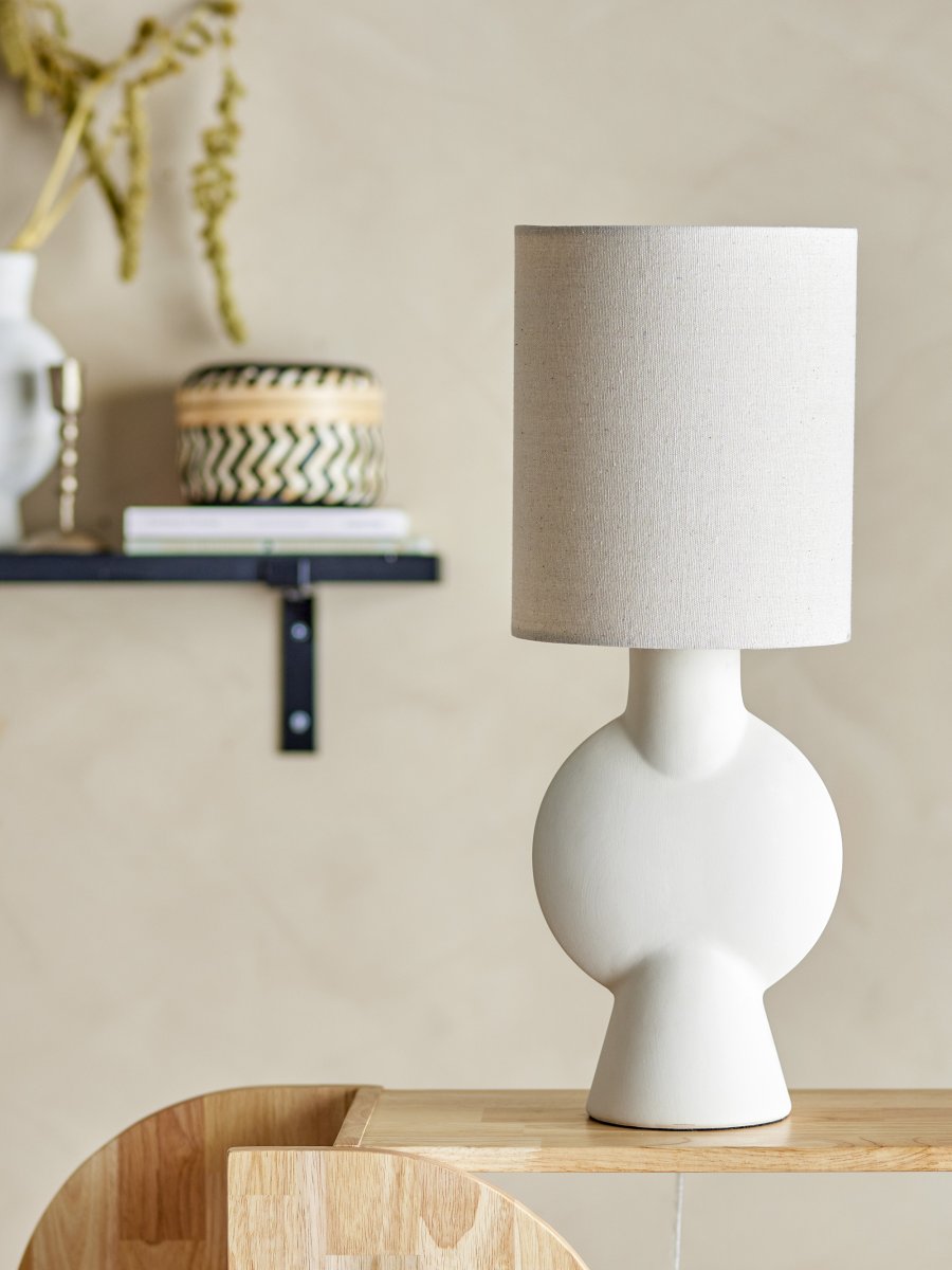 Sergio 55cm Naturhvit bordlampe Fra Bloomingville - Lampen er glasert med en finish som varierer fra kopi til kopi &ndash; noen har en m&oslash;rkere tone og mer tekstur, noe som gj&oslash;r hver lampe unik i sitt uttrykk.