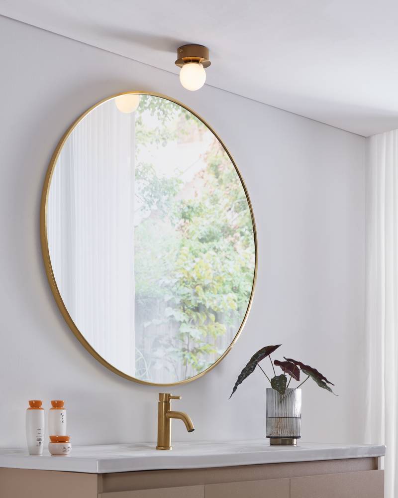 Mosiano Ø11 Gull baderomslampe Fra Eglo - Med sin myke, runde glasskuppel og den gullfargede metallbasen skaper den et varmt og innbydende lys, perfekt for mindre rom som ganger eller bad.