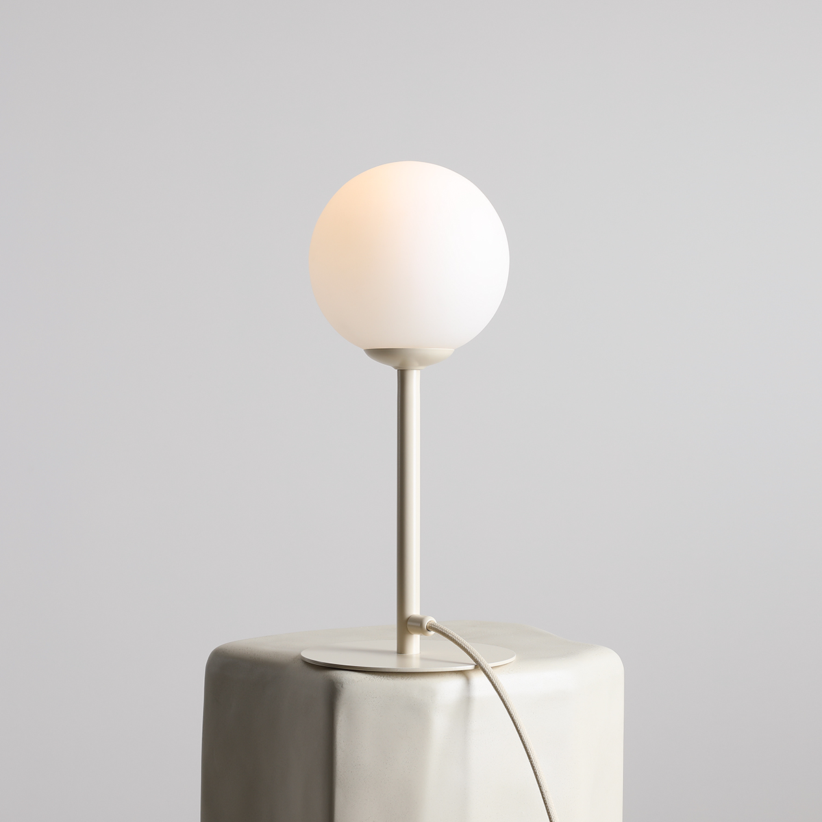 Pinne 35cm Krem bordlampe Fra Artera - Den runde opalgloben sprer et mykt og behagelig lys, perfekt for å skape en varm og innbydende atmosfære i rommet.