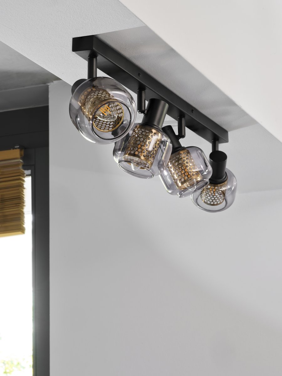 Firefly 4 Svart spotlight Fra Ledvance - De r&ouml;rliga spotlightsen med sk&auml;rmar av gr&aring;tonat glas i kombination med de guldiga detaljh&ouml;ljet som omfamnar ljusk&auml;llorna bidrar med en elegans till rummet.