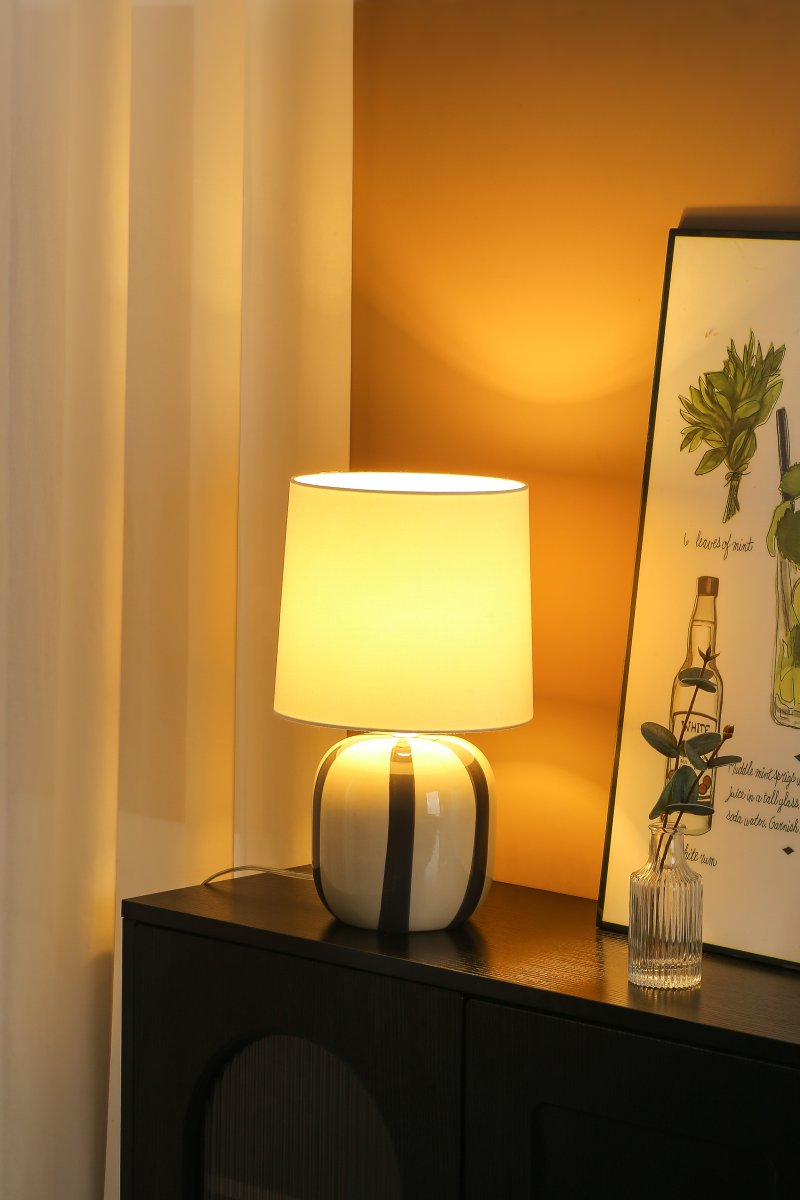 Pholca 38cm Hvit/grå bordlampe Fra Nordic Lighting - Lampefoten er laget av keramikk med en kremhvit base og gr&aring; striper som skaper liv og karakter.