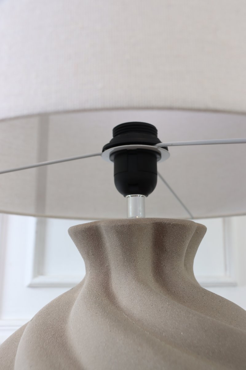 Vindel 52cm Sand bordlampe Fra Lampan - Lampefoten i keramikk har en sandfarget, strukturert overflate og et mykt virvlende design som gir et livlig og skulpturelt uttrykk.