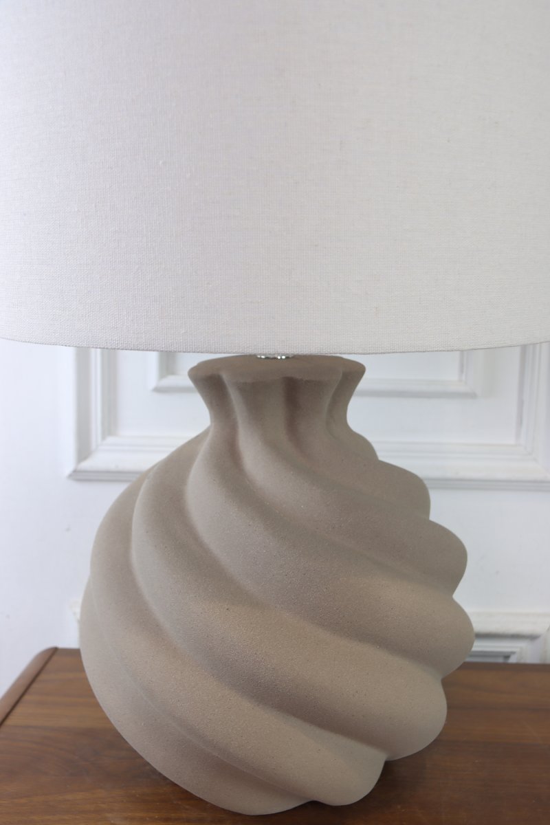 Vindel 52cm Sand bordlampe Fra Lampan - Lampefoten i keramikk har en sandfarget, strukturert overflate og et mykt virvlende design som gir et livlig og skulpturelt uttrykk.