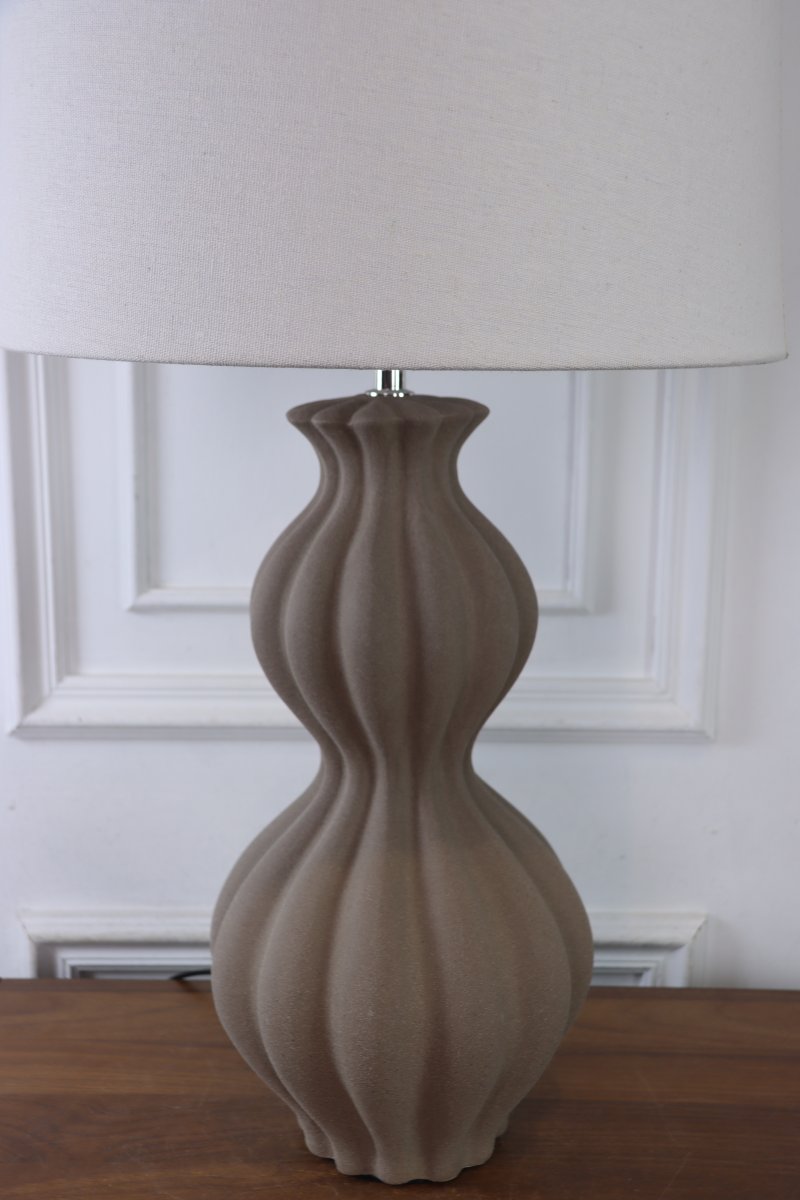 Amfora 67cm Sand bordlampe Fra Lampan - Lampefoten i keramikk har en vakkert formet silhuett med myke linjer og en strukturert overflate i sandfarge som gir et naturlig og harmonisk uttrykk.