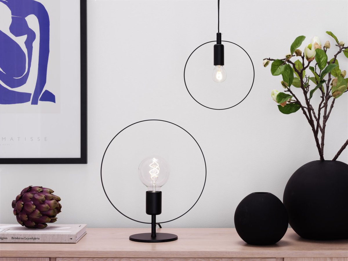 Spartan ringo 35cm Svart bordlampe Fra Cottex - Spartan Ringo bordlampe i metall er en moderne og minimalistisk lampe som trekker blikket med sitt elegante sirkulære design.