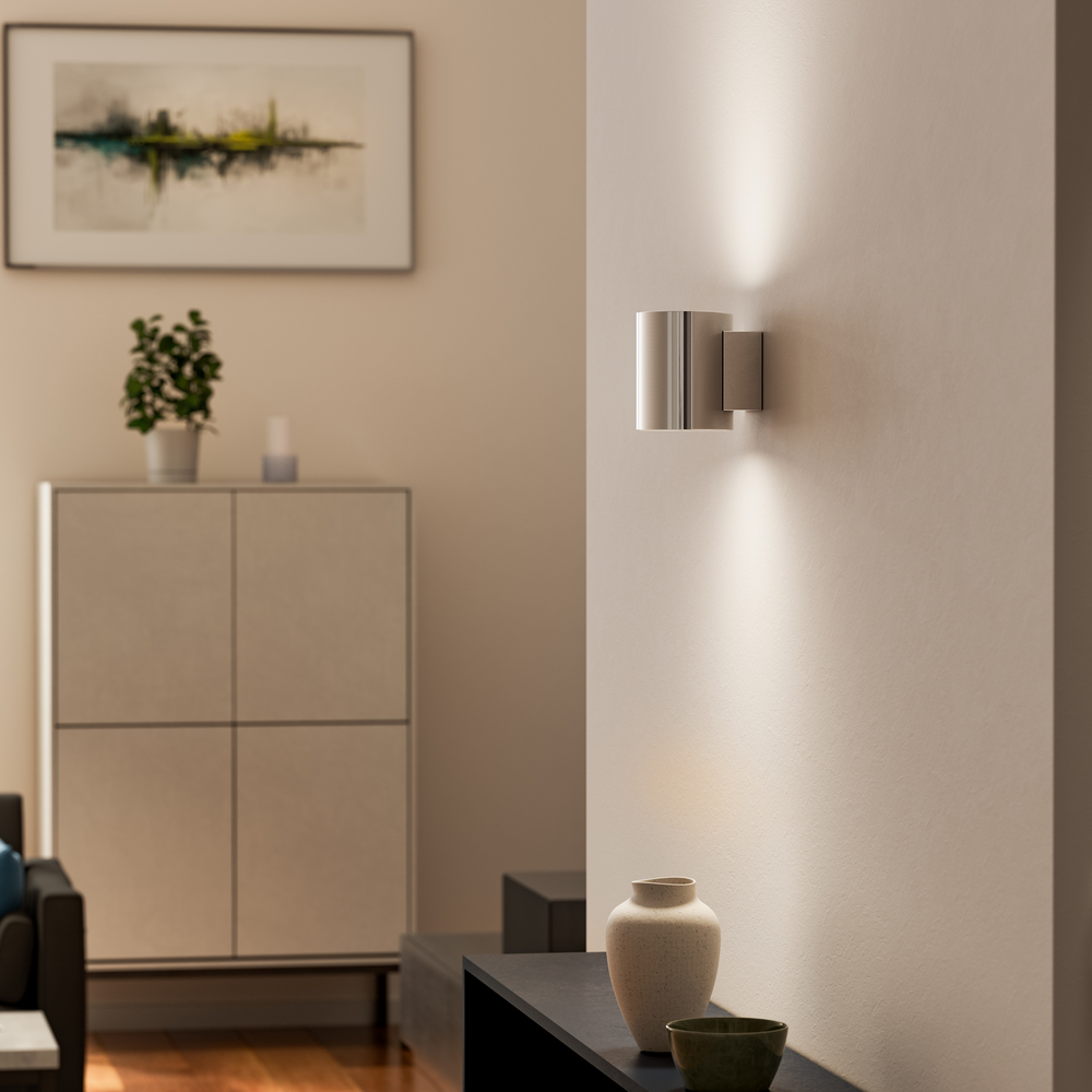 Evoke S Krom vegglampe Fra Herstal - Den smarta konstruktionen med b&aring;de upp- och nerljus g&ouml;r den till ett utm&auml;rkt val f&ouml;r att belysa din hall, vardagsrum eller sovrum p&aring; ett subtilt men effektfullt s&auml;tt.