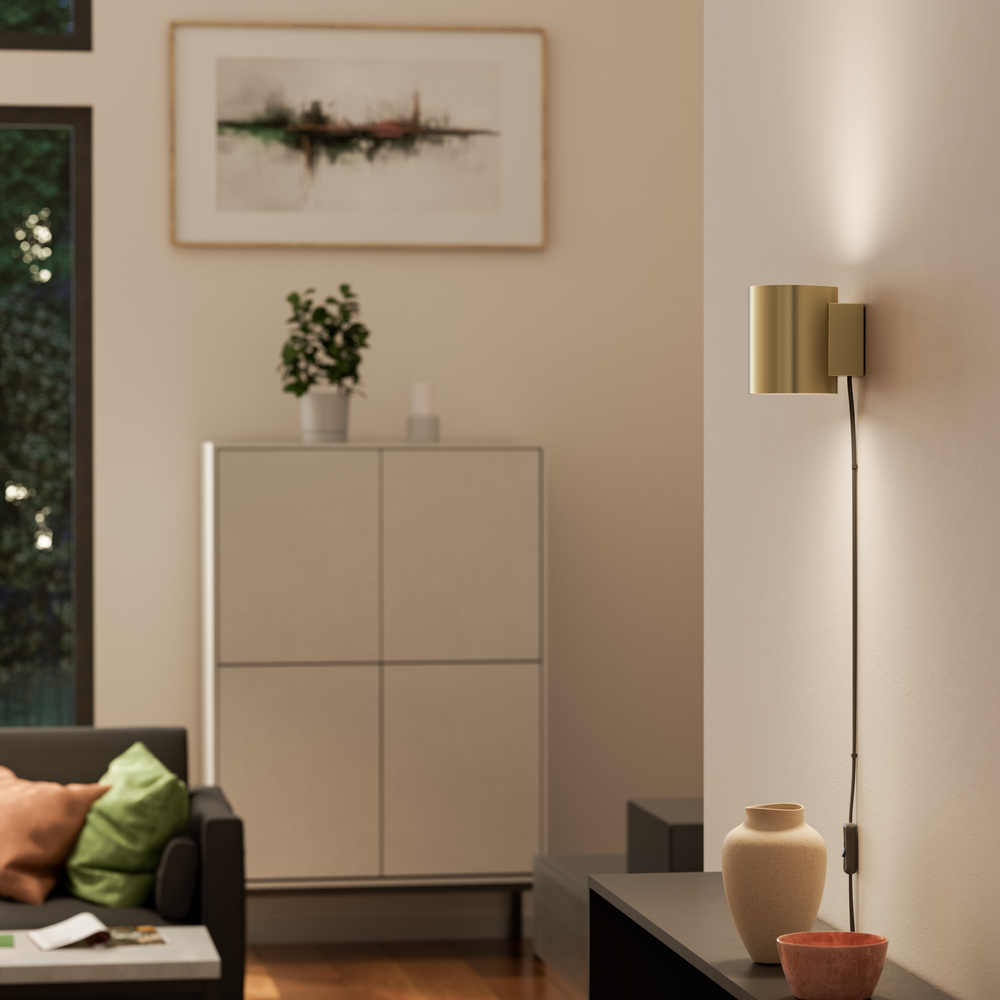 Evoke S Sateng messing vegglampe Fra Herstal - Den smarta konstruktionen med b&aring;de upp- och nerljus g&ouml;r den till ett utm&auml;rkt val f&ouml;r att belysa din hall, vardagsrum eller sovrum p&aring; ett subtilt men effektfullt s&auml;tt.