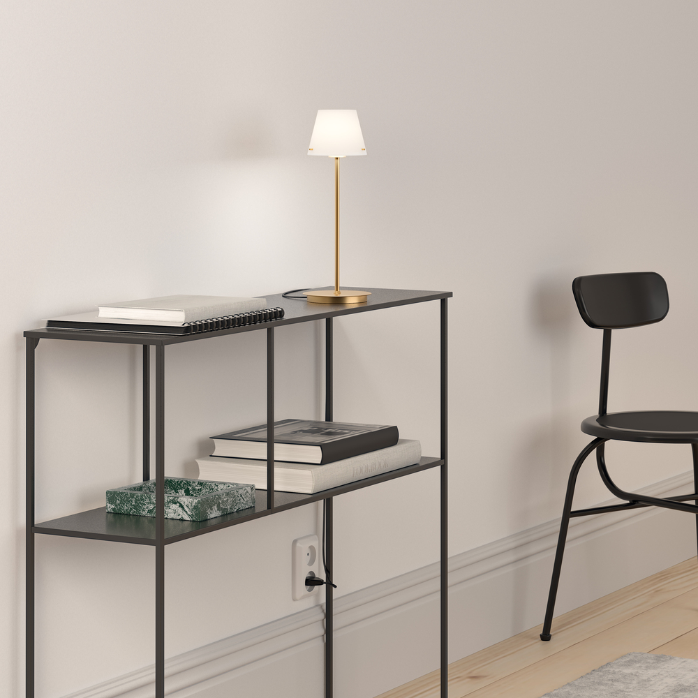 Gil 34cm Sateng messing bordlampe Fra Herstal - Den er laget av metall med en sateng messingfinish og har en hvit glassskjerm som sprer et mykt og behagelig lys.