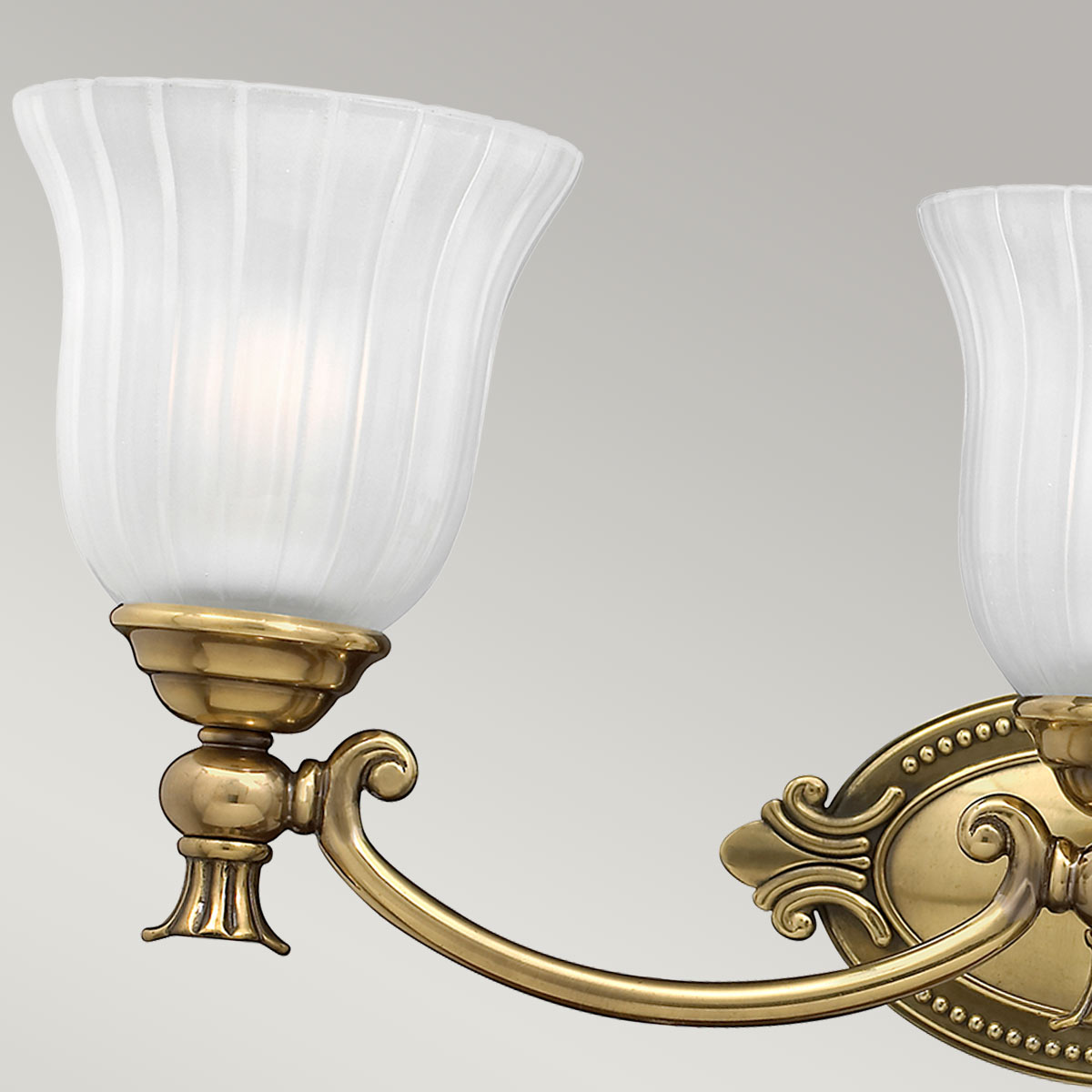 Francoise 64cm Messing baderomslampe Fra Elstead Lighting - Den har en vakker kuppel av frostet glass med riflet design som sprer et mykt lys, og den dekorative messingbasen gir et stilig preg.