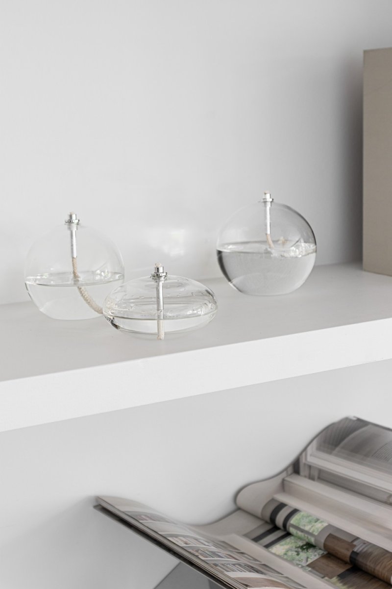 Oljelampa Aura Stor Klart glass Fra Mette Ditmer - Dens elegante design og r&oslash;ykfargede glass sprer et mykt, varmt lys som gir en rolig og koselig f&oslash;lelse.