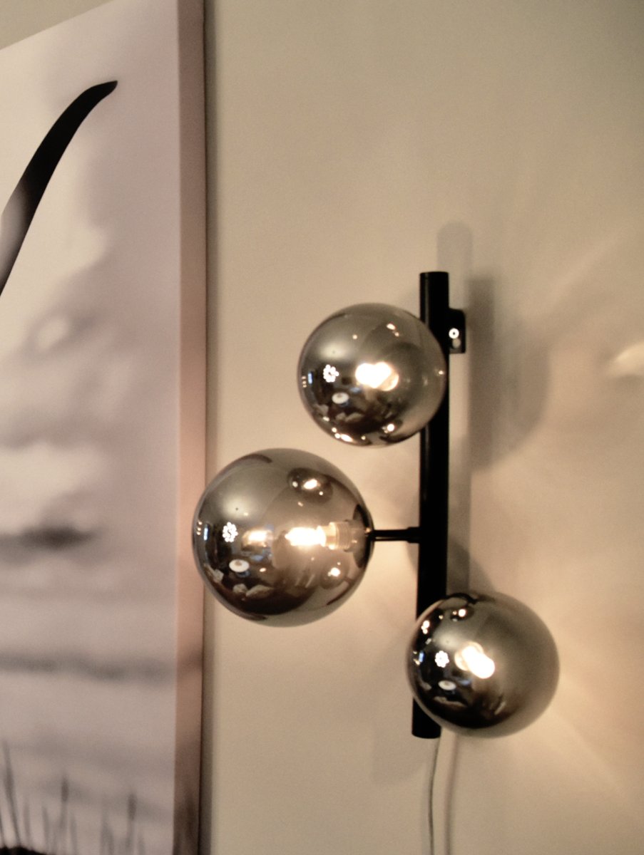 Molekyl 36cm Røykgrå vegglampe Fra Aneta Lighting - Den er laget av svart metall og har skjermer i røykfarget glass som sprer et mykt og behagelig lys.