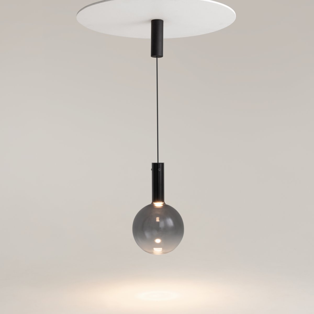 Nebula Ø25 Svart Taklampe Fra Maytoni - Den blåste glasskulen, med en gradient fra en mørkere tone øverst til nesten gjennomsiktig nederst, gir en hypnotisk effekt.