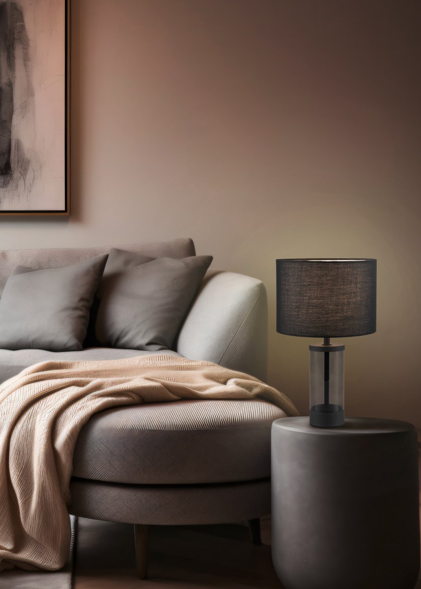 Grazia 34cm Svart bordlampe Fra Trio Lighting - Bordlampen Grazia kombinerer en elegant stoffskjerm med en stilig sylindrisk fot i glass og metall, som gir et harmonisk og sofistikert inntrykk.