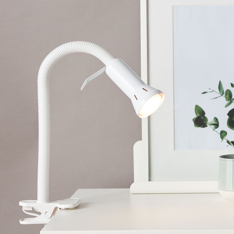 Flex Hvit klemmelampe Fra Brilliant - Flex er en praktisk klemmelampe som enkelt festes til kanten av et bord eller en hylle ved hjelp av klemmefoten &ndash; perfekt der plassen er begrenset og en vanlig lampefot ikke f&aring;r plass.